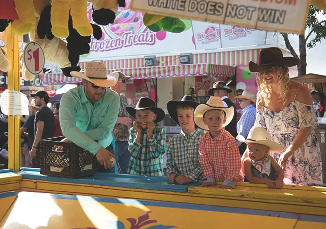 Young family playing Carnival Games at the Stampede Midway
