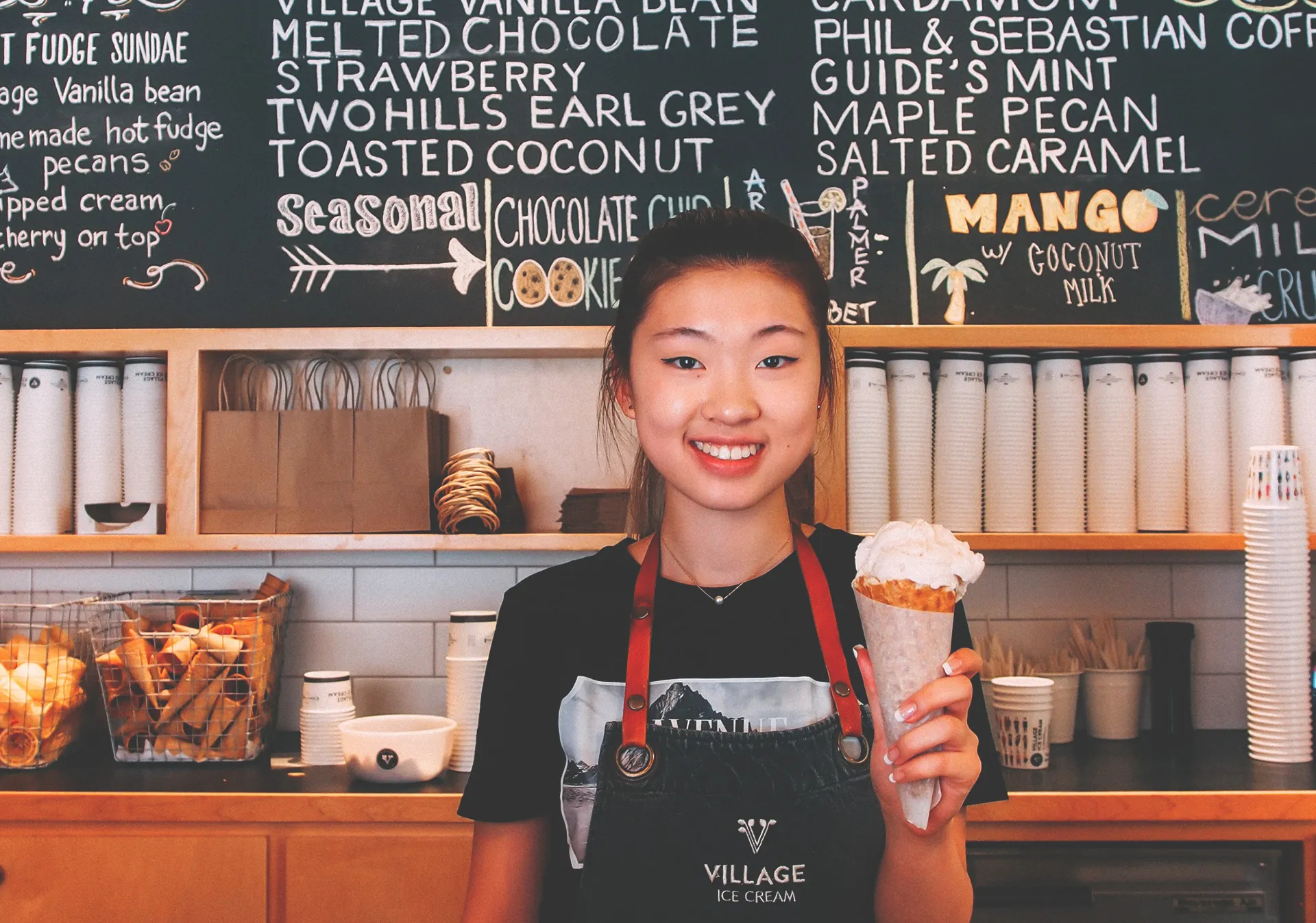 employee at village ice cream holding a cone