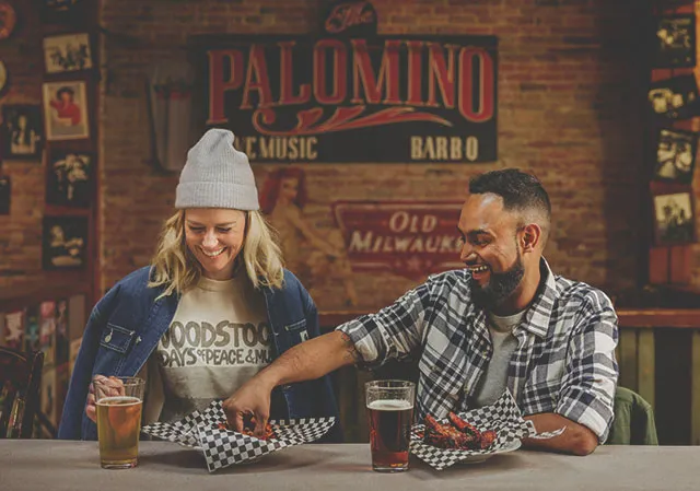 couple eats BBQ wings at The Palomino Smokehouse