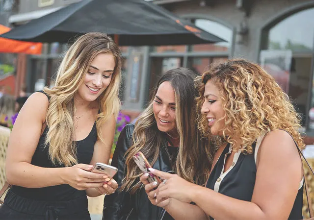 three ladies interacting with the self-guided Alberta Food tour app