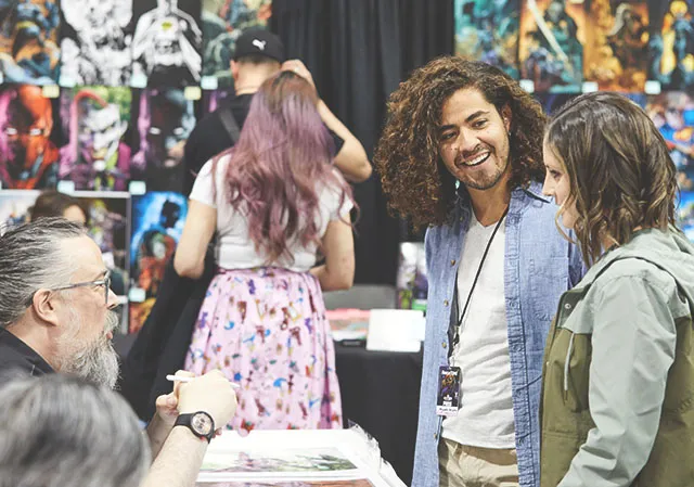 two friends speaking with an artist at Calgary Expo