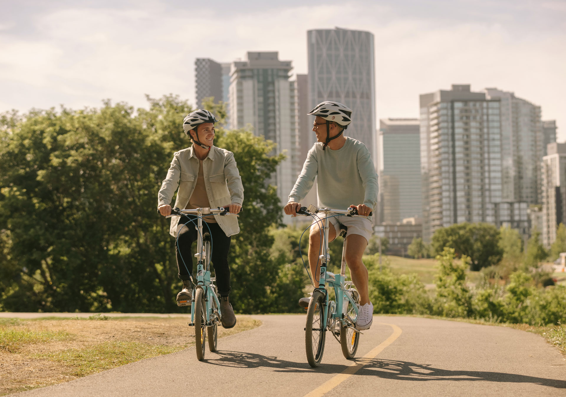 Two men biking in Calgary along the river path.