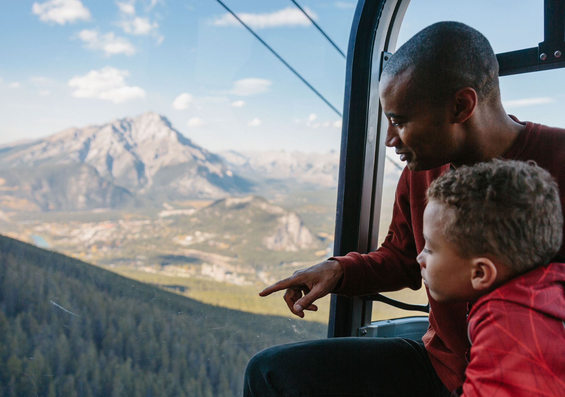 Father and son riding the Banff Gondola in the summer