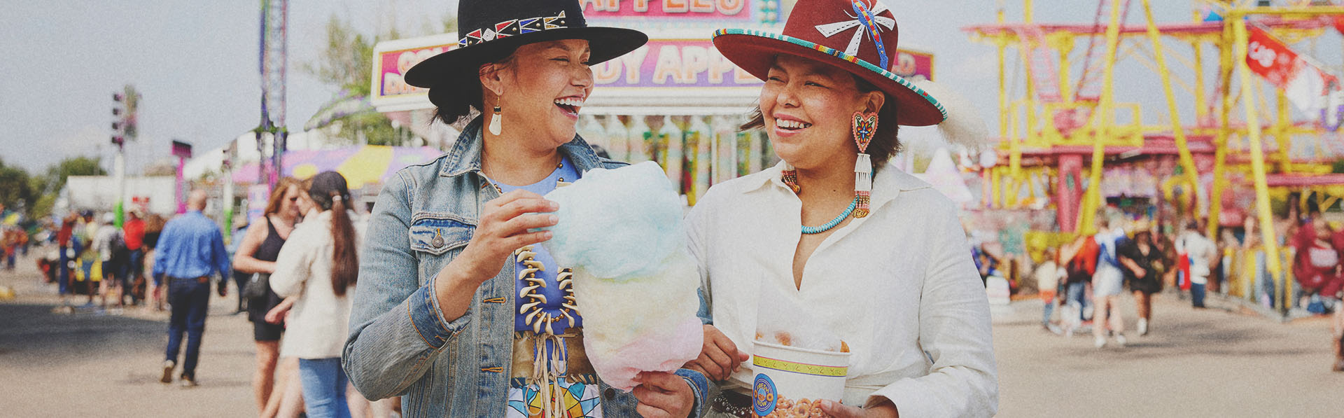 two Indigenous ladies enjoying some classic midway food at Calgary Stampede
