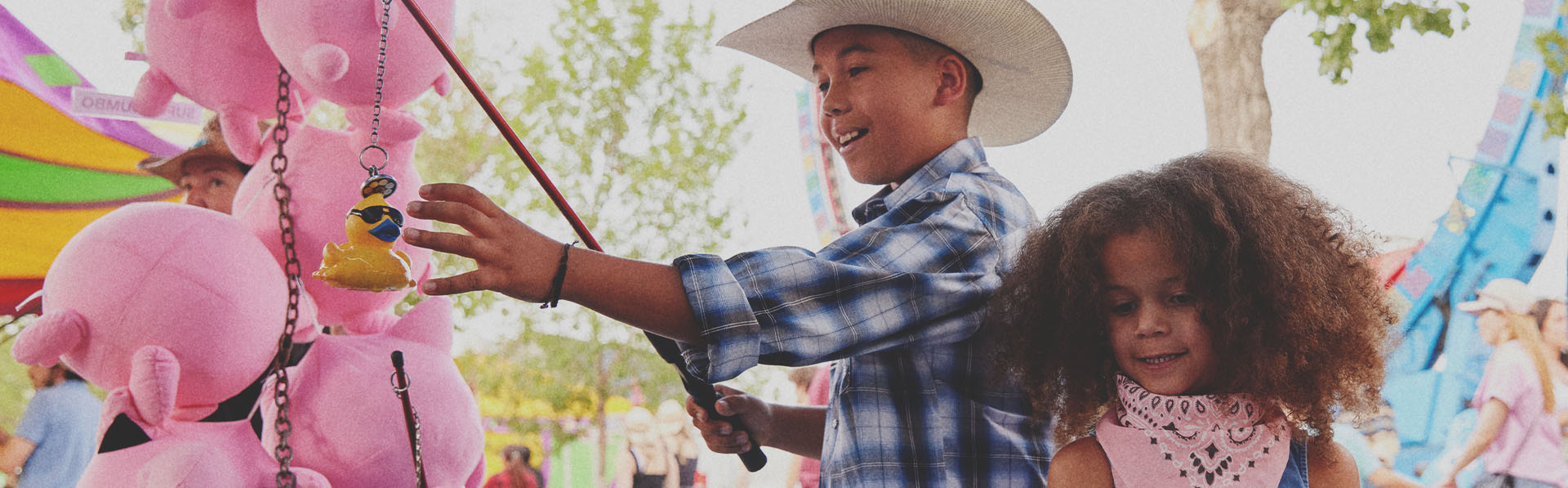two children playing games at the Calgary Stampede Midway