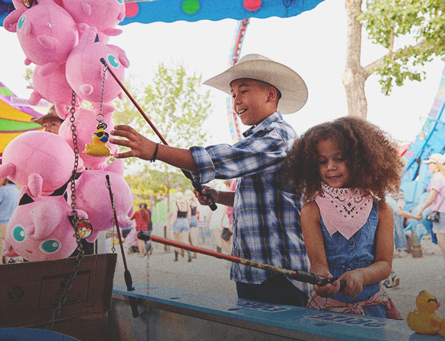 two children playing games at the Calgary Stampede Midway