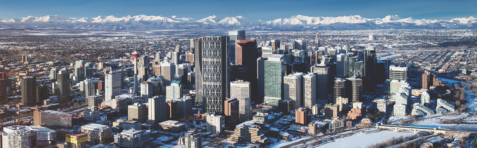 aerial of the Calgary skyline on a clear day during winter with the Rocky Mountains in the background