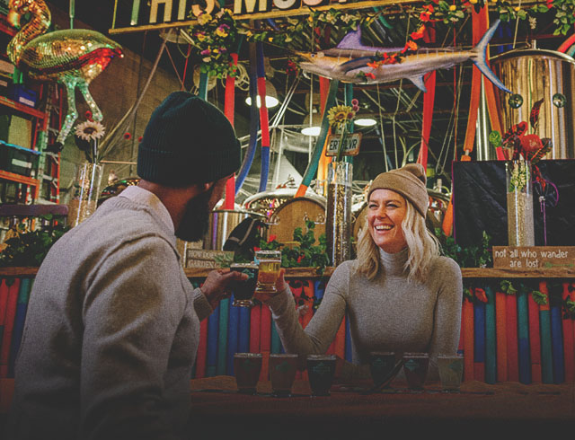 A smiling couple toasting with beer glasses