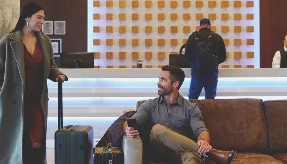 two people greet each other in the lobby of a Calgary Hotel