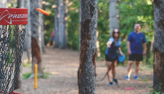 couple playing disc golf in baker park