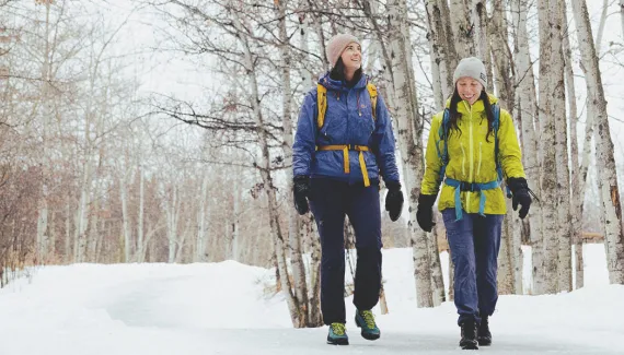 two friend hiking through Fish Creek Provincial Park in winter