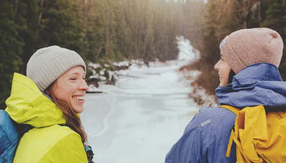 two people hiking through a creek in Fish Creek Provincial Park