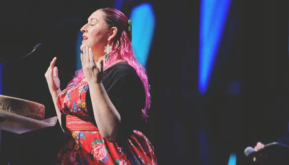 a woman speaking at a podium on stage at Calgary TELUS Convention Centre