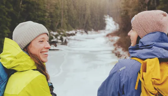 couple takes a break from a winter hike in Fish Creek Park