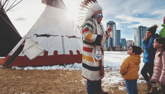 Indigenous representative guiding a family at The Confluence Calgary