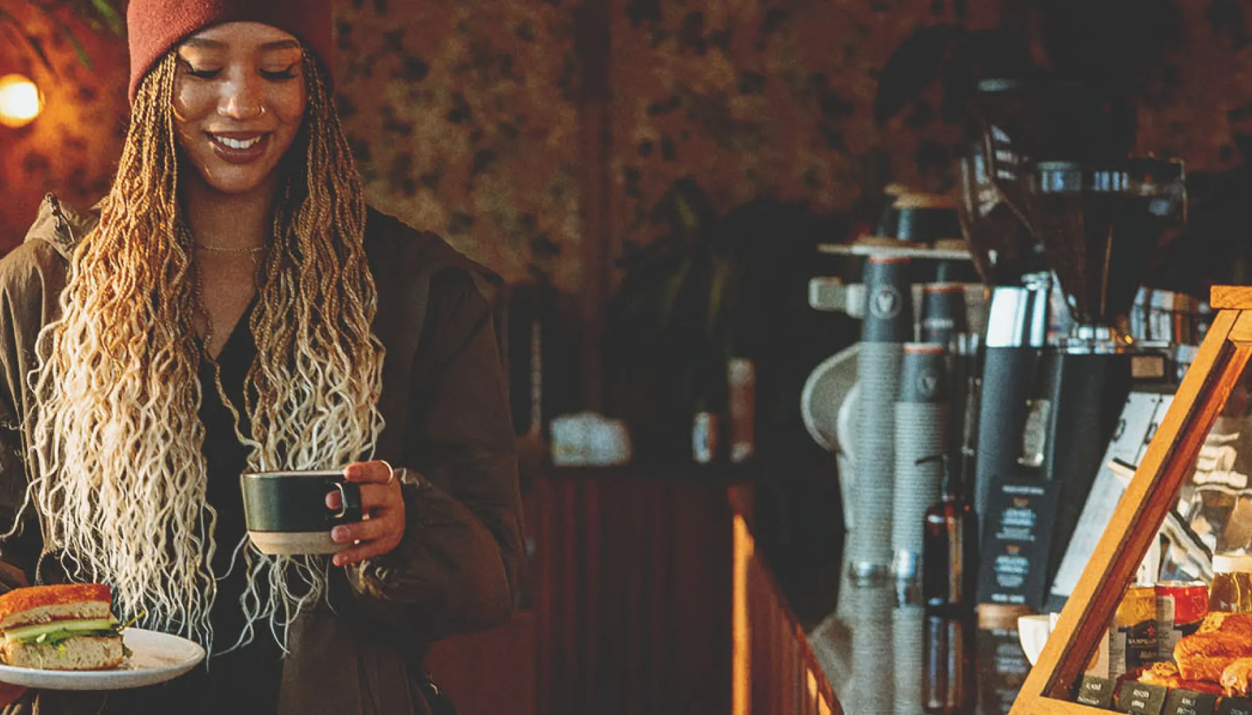 woman carrying a sandwich and latte in a local calgary coffee shop