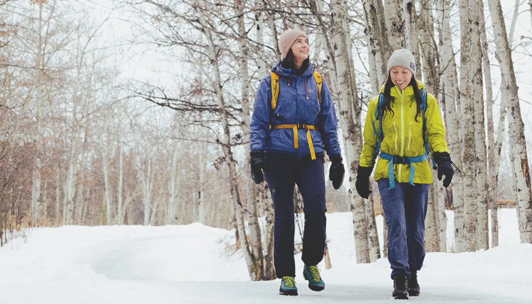 two friend hiking through Fish Creek Provincial Park in winter