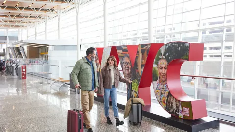 couple walking through YYC Calgary International Airport with luggage