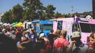 crowds of people ordering from food trucks at Marda Gras Street Festival