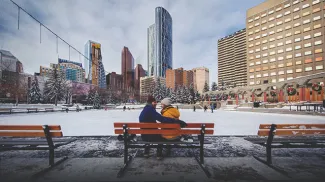 couple takes a break from skating on a bench in Calgary's Olympic Plaza downtown