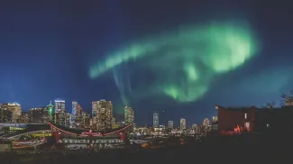 The Northern Lights shine brightly above downtown Calgary at night