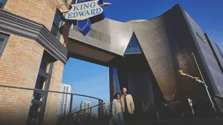 couple walking in Calgary's East Village beside Studio Bell and King Eddy