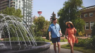 couple walking through a downtown Calgary Park on a sunny summer day