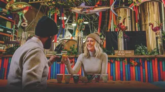 A smiling couple toasting with beer glasses