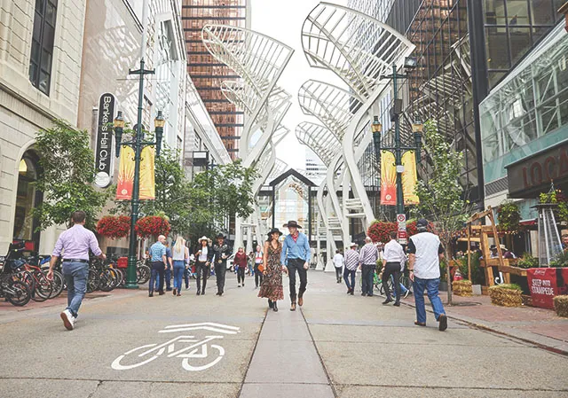 couple walking along Stephen Avenue in Calgary beneath the Galleria Trees