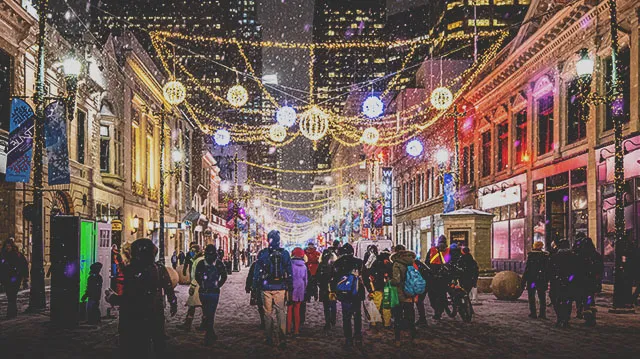 crowd exploring the Chinook Blast installations along Stephen Avenue during snowfall