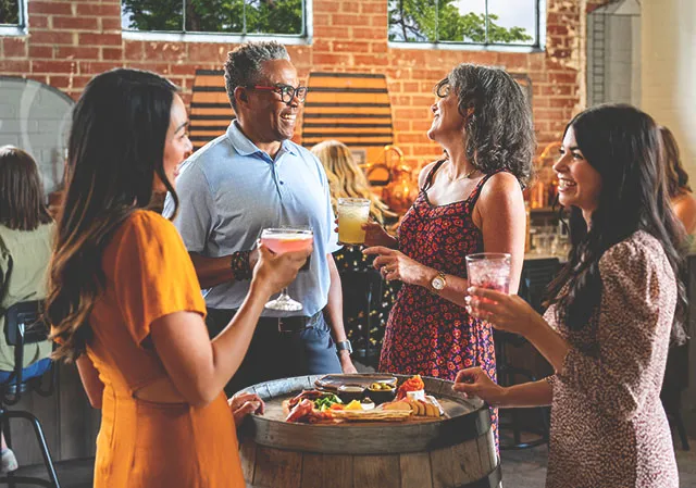 group of 4 enjoy drinks and appetizers at Veranda in the Currie Barracks