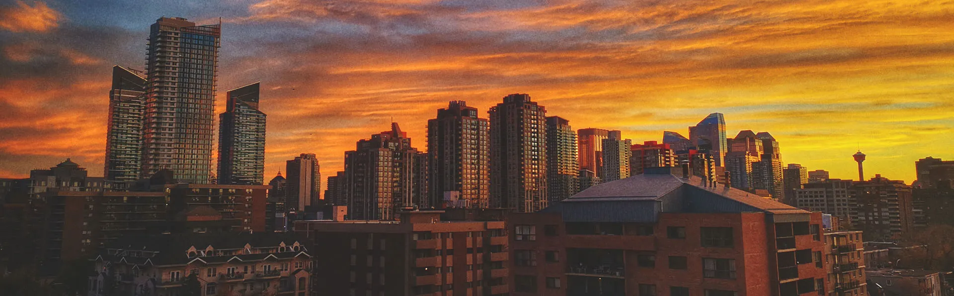 downtown Calgary skyline with a vibrant orange, yellow, blue and purple sunset