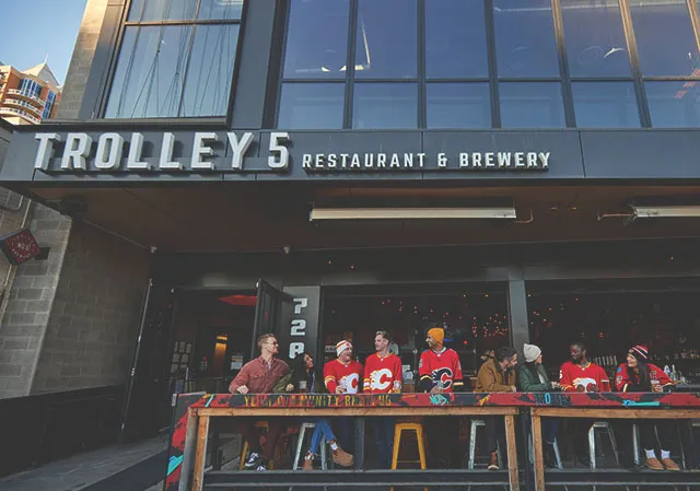 Group of friends drinking beer on the Trolley5 patio before a Calgary Flames Game