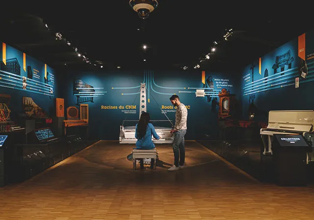 couple interacting with musical instrument exhibits at Studio Bell