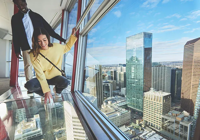 couple standing on the glass floor of the Calgary Tower observation deck