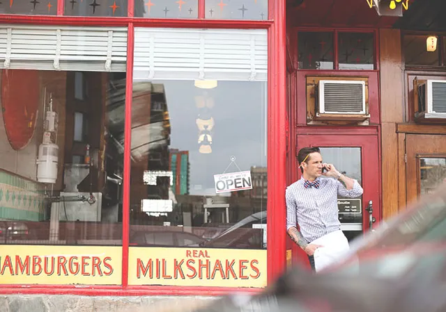 server stands outside Galaxie Diner's vintage exterior