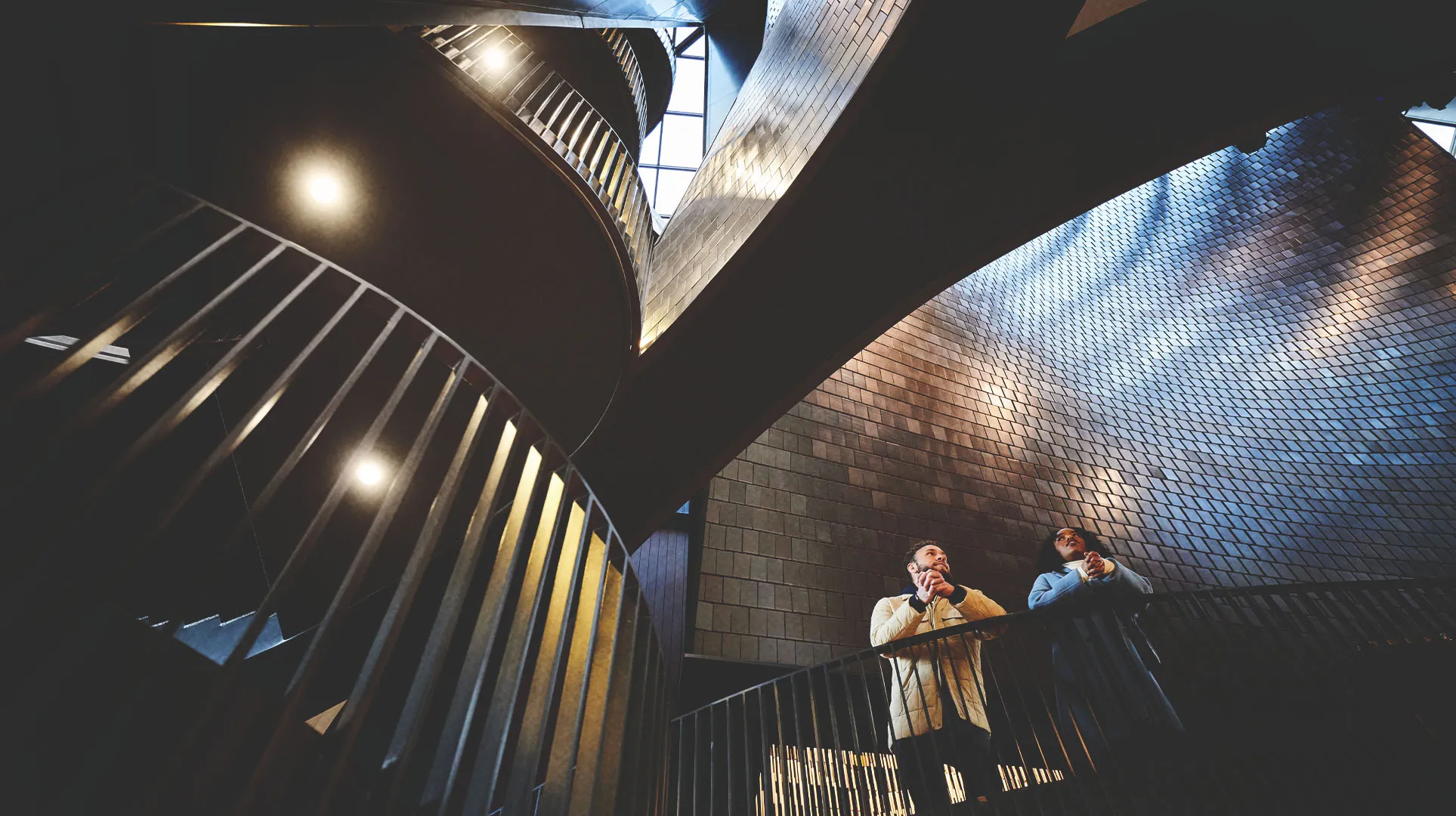 Man and women marvel at the Studio Bell architecture. 