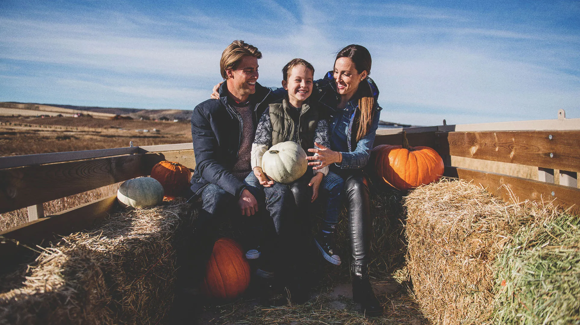 family of three on an autumn Hay Ride at Granary Road