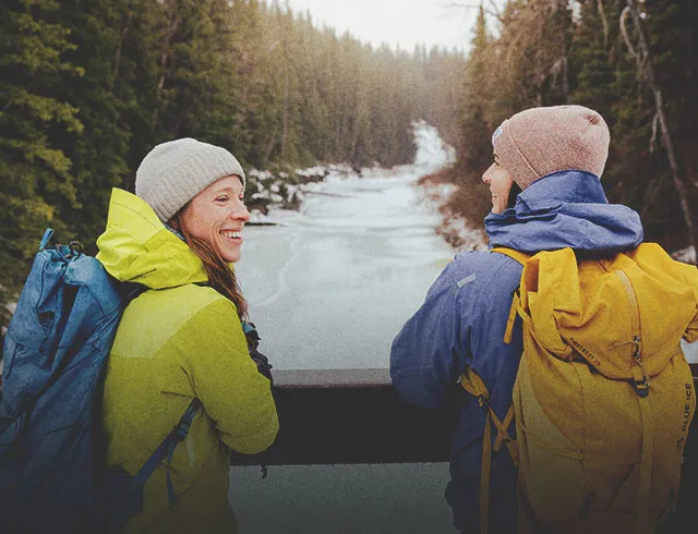 two people hiking through a creek in Fish Creek Provincial Park